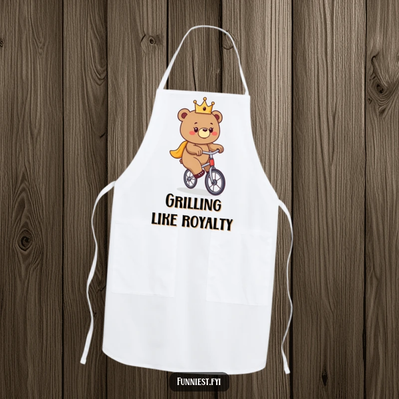 Funny bear apron, a crowned bear hilariously attempting to ride a unicycle, ready for kitchen duty.