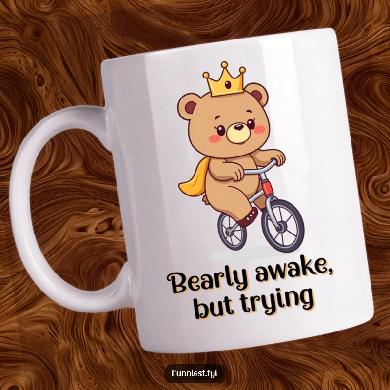 Funny bear mug, a bear wearing a tiny crown attempts to balance on a unicycle with a determined grin.