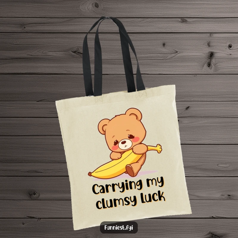 Funny clumsy teddy bear character tripping over a runaway banana on a durable and humorous tote bag.